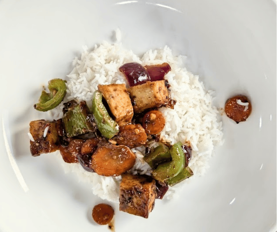 A bold, flavor packed spicy peanut tofu stir fry served hot over fluffy rice.