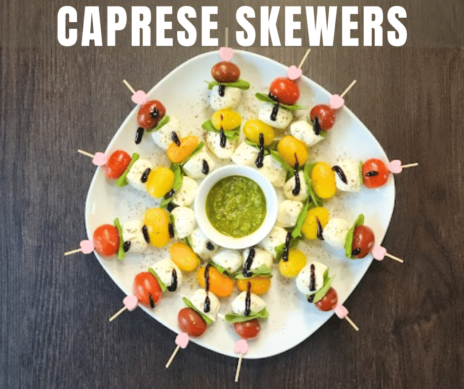 Bite-sized caprese skewers served with a side of fresh pesto