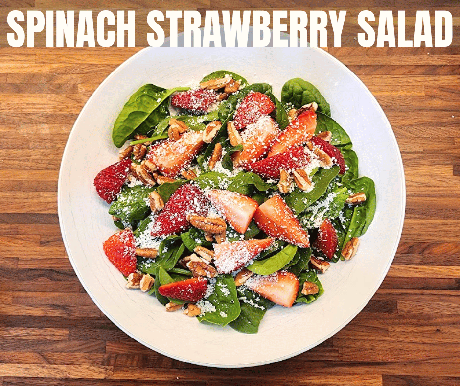 A simple spinach strawberry salad finished with crunchy pecans and crumbled cotija.