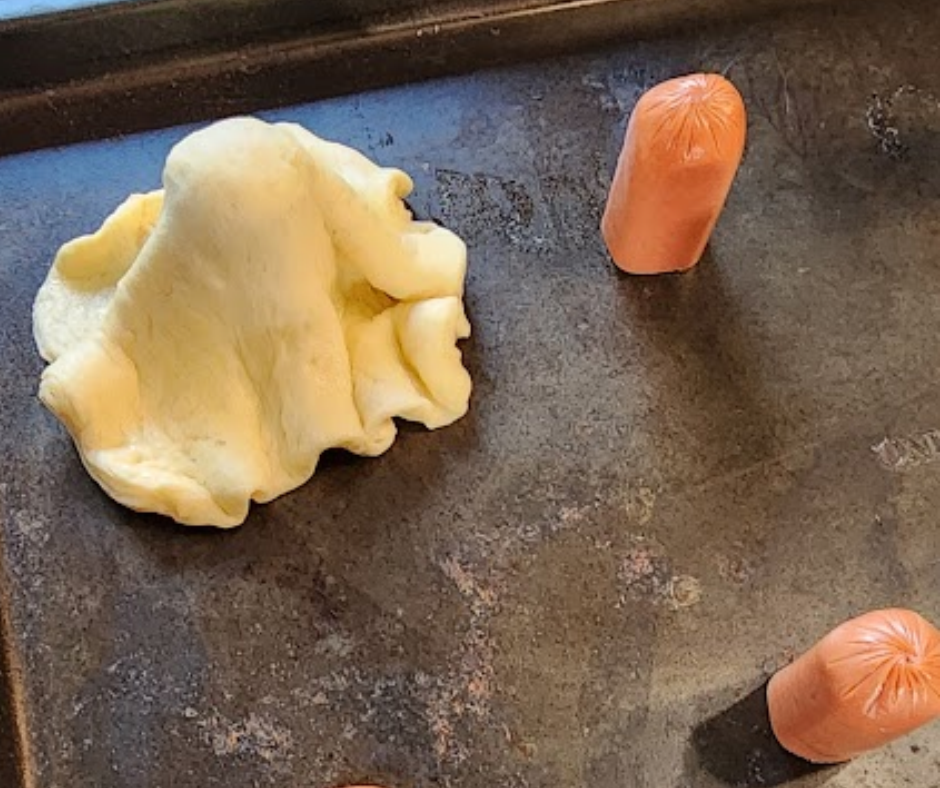 Step 3. Drape the dough over the hot dogs